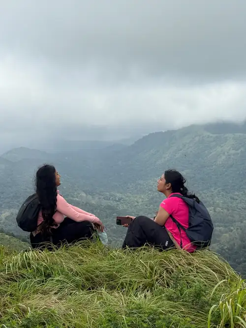 Two community members chatting on a grassy hillside in Silent Valley